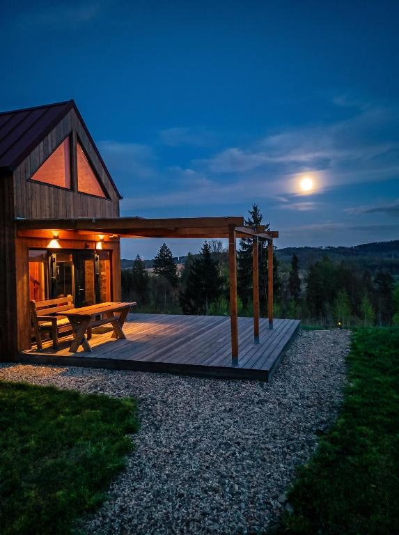 a wooden deck with a bench and a house at Cisza & Natura - Kraina Wygasłych Wulkanów in Radzimowice