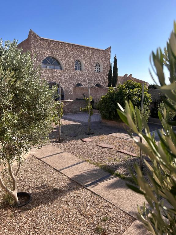 a building with trees in front of it at Dar Joud Kaouki in Sidi Kaouki