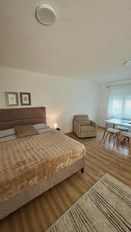 a bedroom with a bed and a chair and a table at JazAzur in Lastva