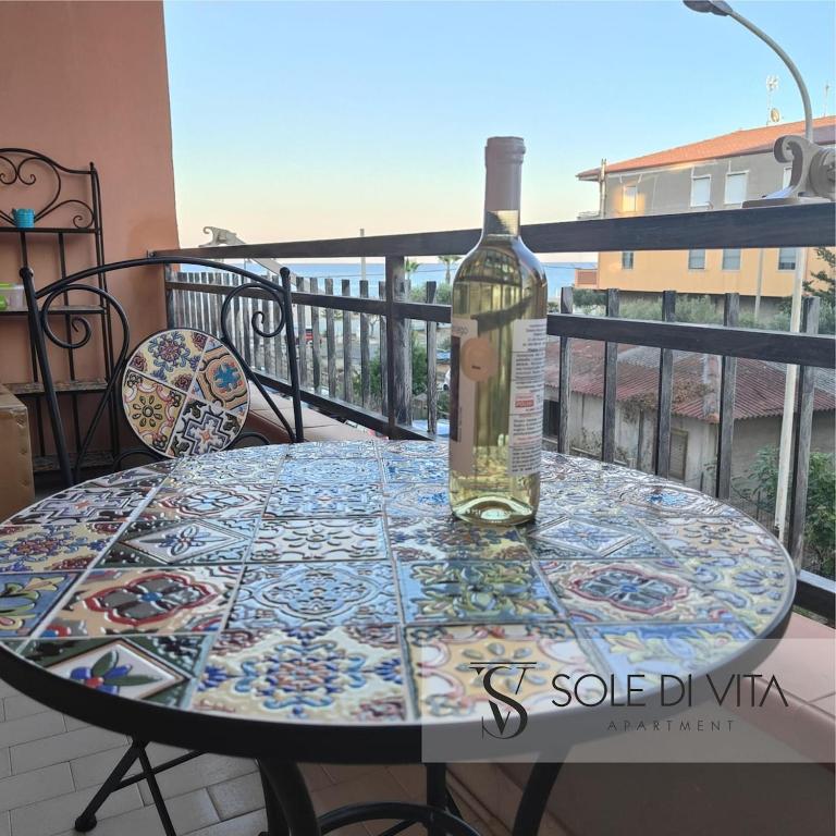 a bottle of wine sitting on a table on a balcony at Sole di Vita in Marina di Strongoli