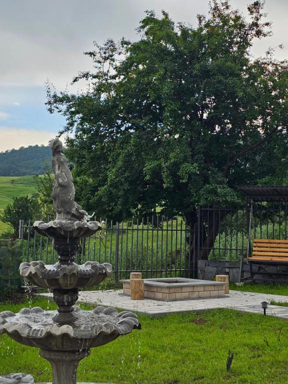 a fountain in the middle of a park with a bench at Amatuni Guest House in Stepʼanavan