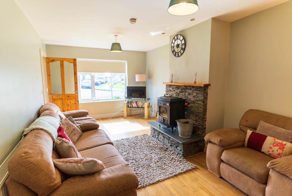 a living room with a couch and a fireplace at Riverview House - Cahersiveen in Cahersiveen