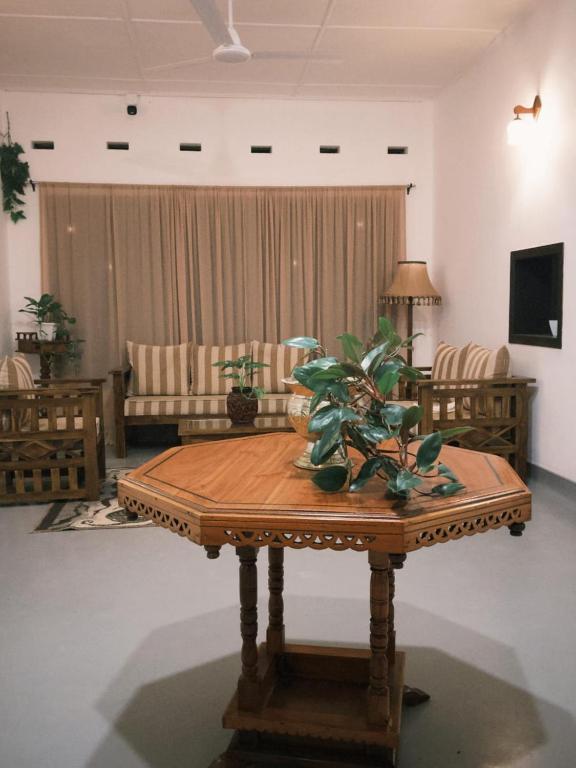 a living room with a wooden table with plants on it at Melani Villa in Kandy