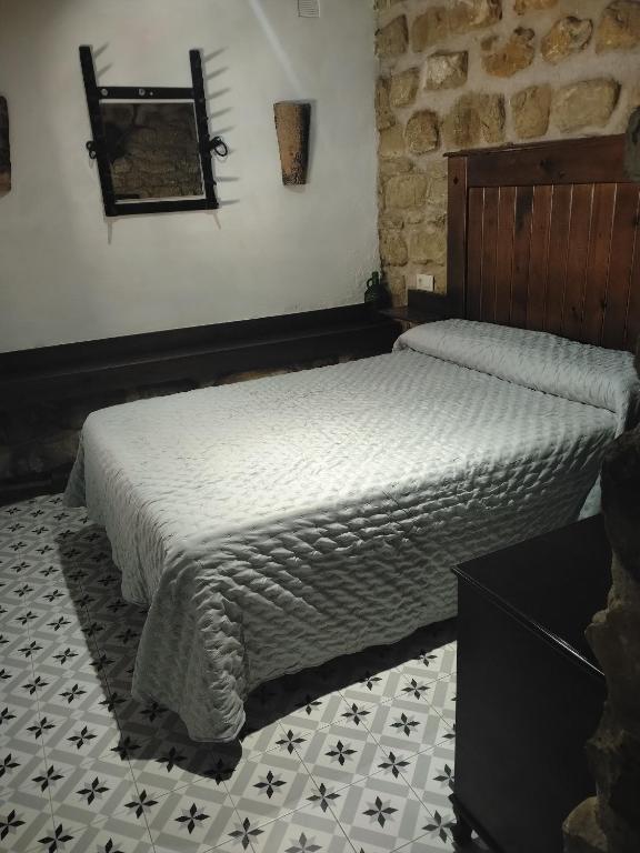 a bedroom with a bed and a mirror on the wall at La alegria de las cuevas in Rus