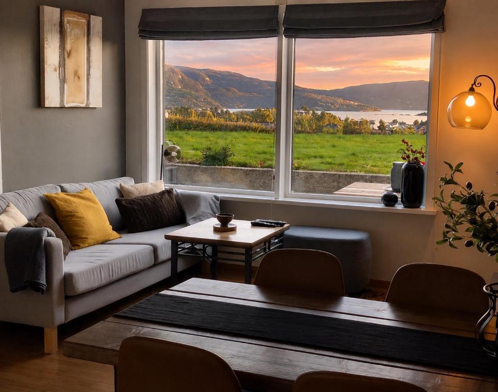 a living room with a couch and a large window at Cozy Landscape House, Near pulpit Rock in Strand