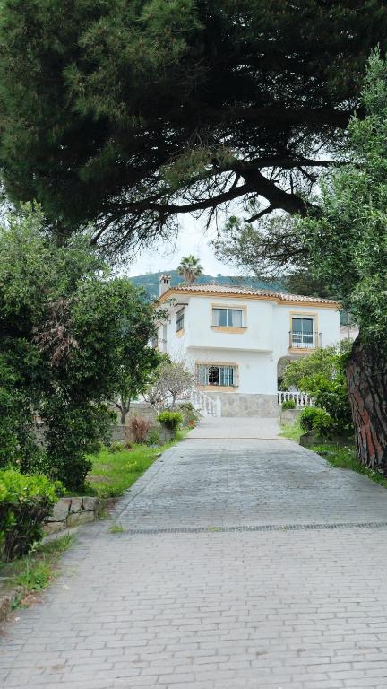 a large white house with a driveway at La Casuca in El Pelayo