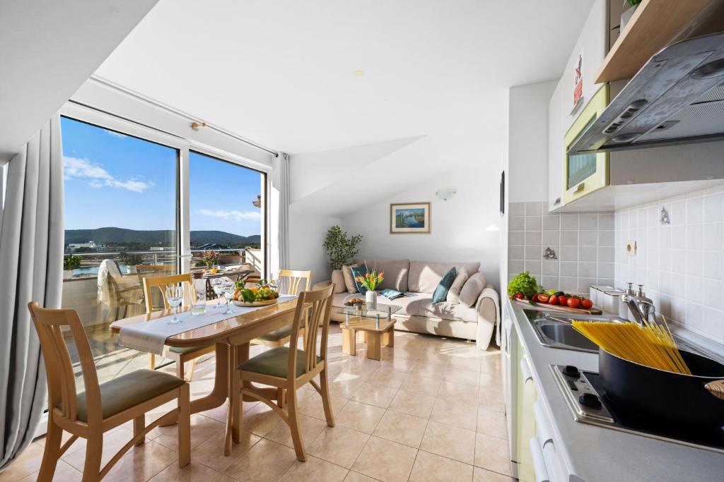 a kitchen and living room with a table and chairs at Villa Baron - Adriatic Sea View in Šibenik