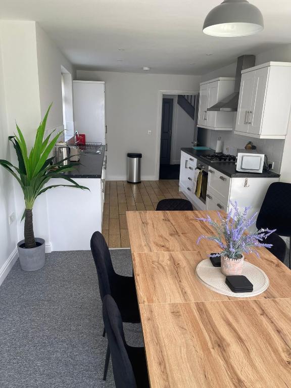 a kitchen and dining room with a wooden table and chairs at Modern spacious private detached house in Beeston