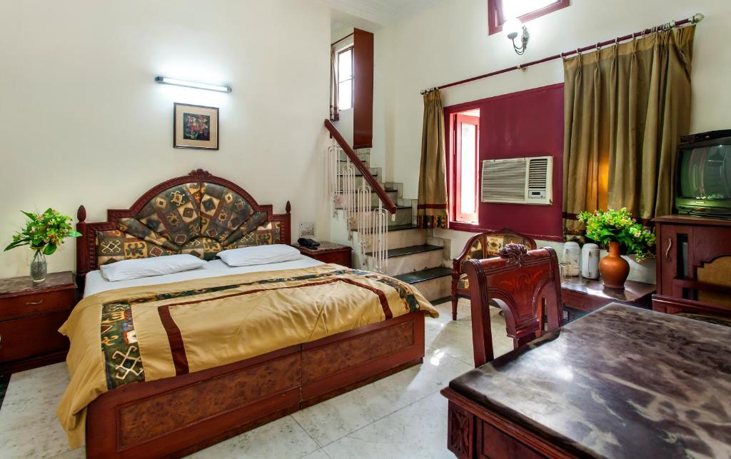 1 dormitorio con 1 cama y TV. en Hotel Sunshine en Nueva Delhi