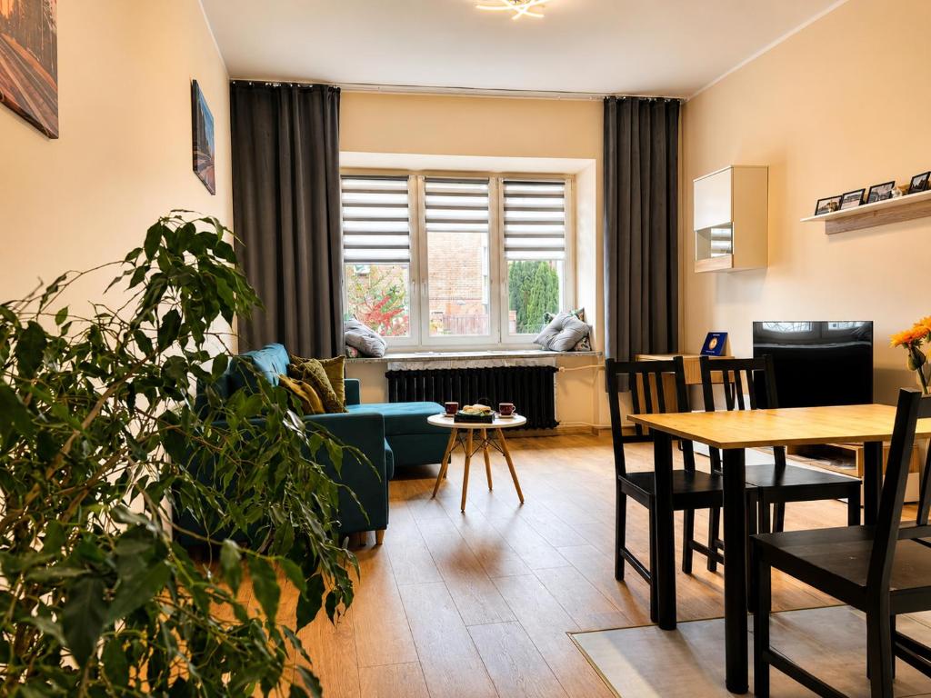 a living room with a blue couch and a table at Apart Brzeg in Brzeg