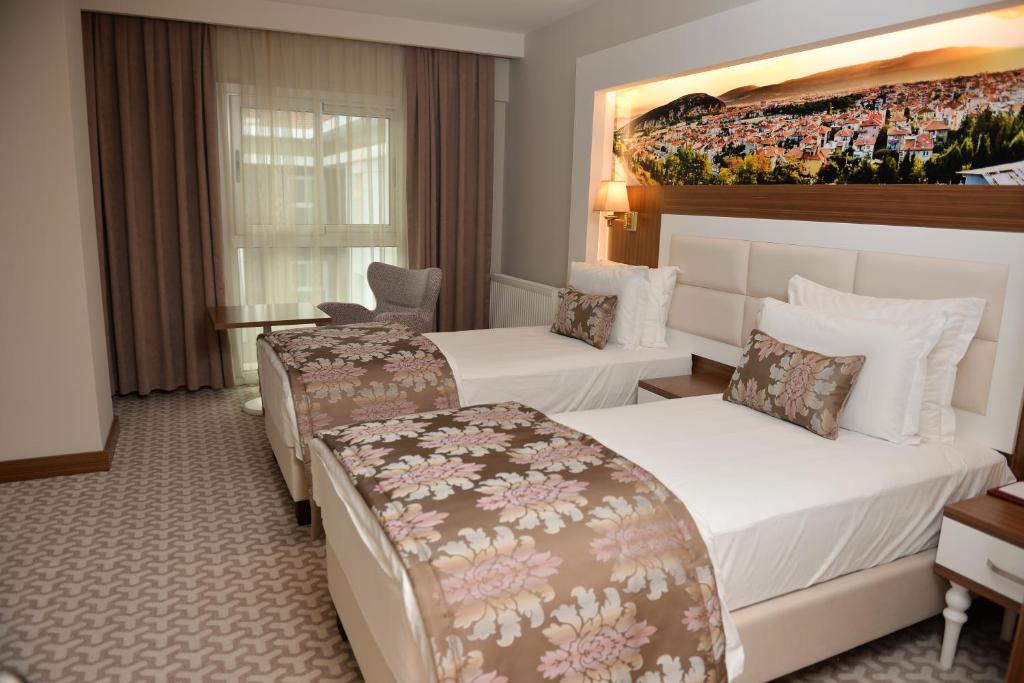 una habitación de hotel con 2 camas y un cuadro en la pared en Tuna Otel Rezi̇dans en Gülağzı