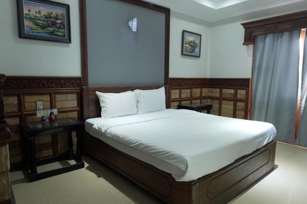 a bedroom with a bed and a window at Dara Panha Sak Guesthouse in Siem Reap