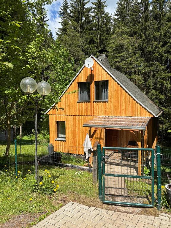 a wooden barn with a chicken coop in a field at Ferienhaus in Finsterbergen in Friedrichroda