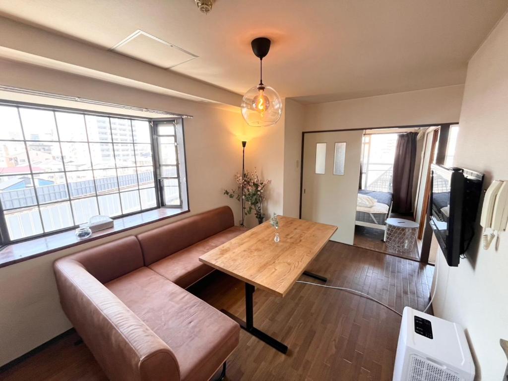 a living room with a couch and a table at High-speed Wi-Fi Station front Kamishinjo in Osaka
