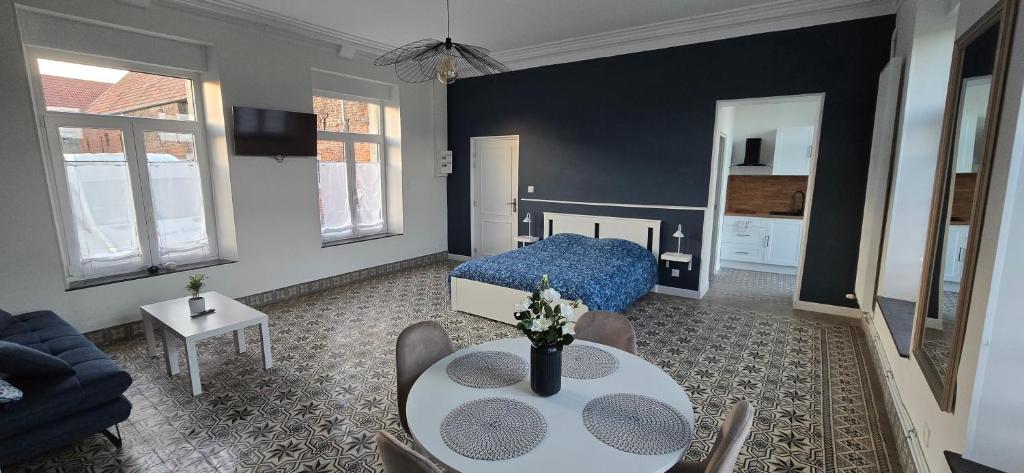 a living room with a blue bed and a table at Gite La Ferme du Château in Cerfontaine