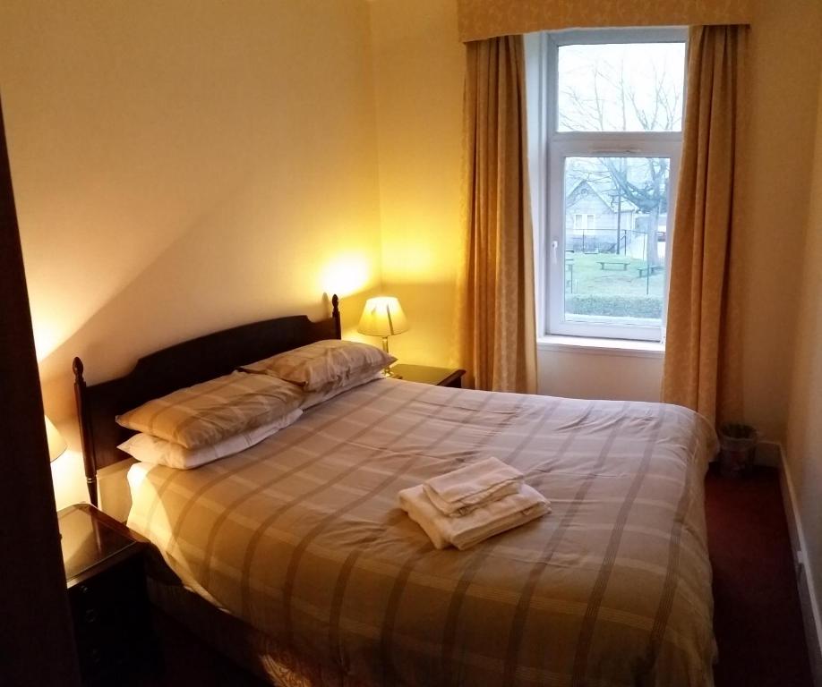 1 dormitorio con 1 cama con 2 toallas en Town Apartments Aberdeen en Aberdeen