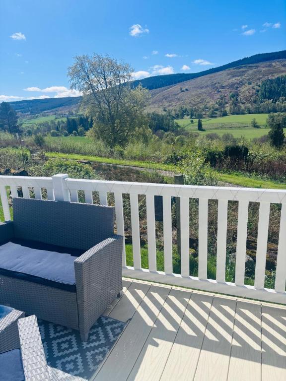 a wicker bench sitting on a deck with a view at Blairgowrie in Ballintuim