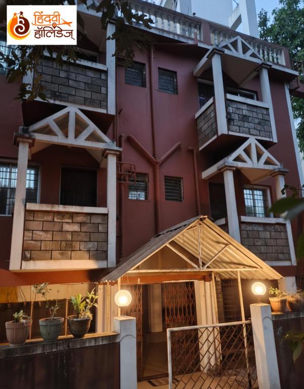 a large red building with a porch in front of it at Hotel Shahi Residency in Panhāla