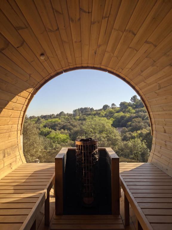an arch in a wooden building with a guitar in the middle at Expériences Les Chênes Verts - Gîtes de charme in Piolenc