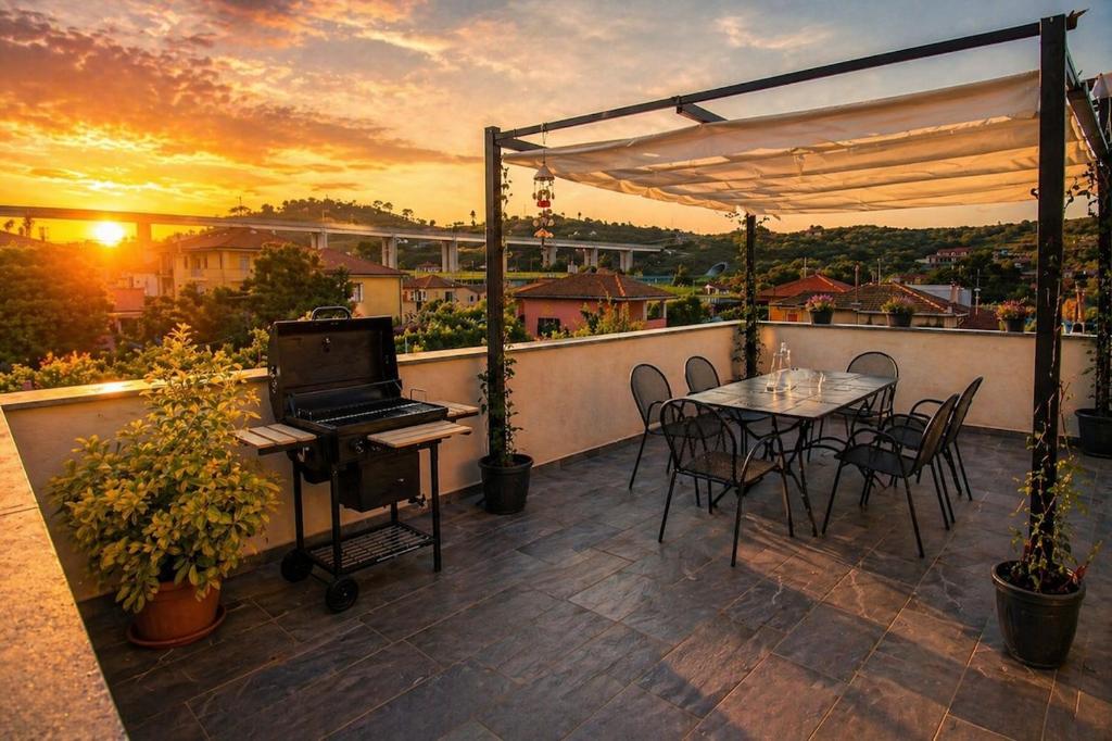 a balcony with a table and a laptop on it at sunset suite con terrazza e barbecue in Imperia