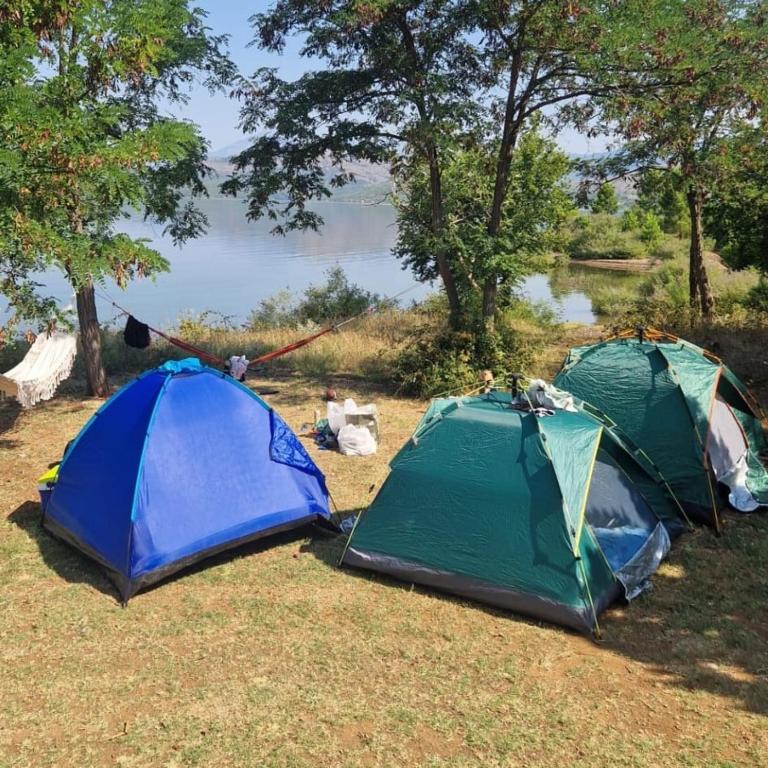 two tents sitting on the grass near a lake at Tent for 2 in Brungaj