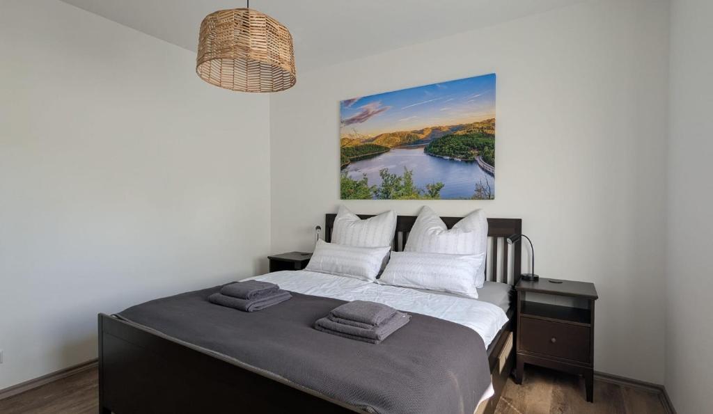 a bedroom with a bed with a painting on the wall at Ferienhaus freiZeit in Rudolstadt