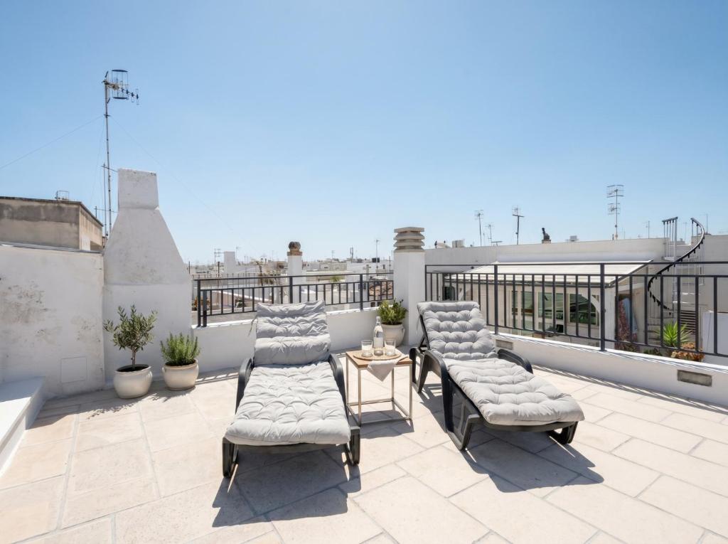 a patio with chairs and a table on a roof at Casa Tino Panorama Skyline in Polignano a Mare
