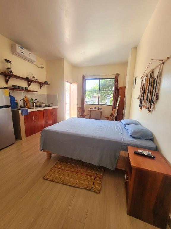 a bedroom with a large bed and a kitchen at Tayta Huasy in Montañita