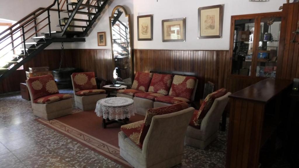 a living room with couches and chairs and a staircase at SUIZO Hotel in Colonia Suiza