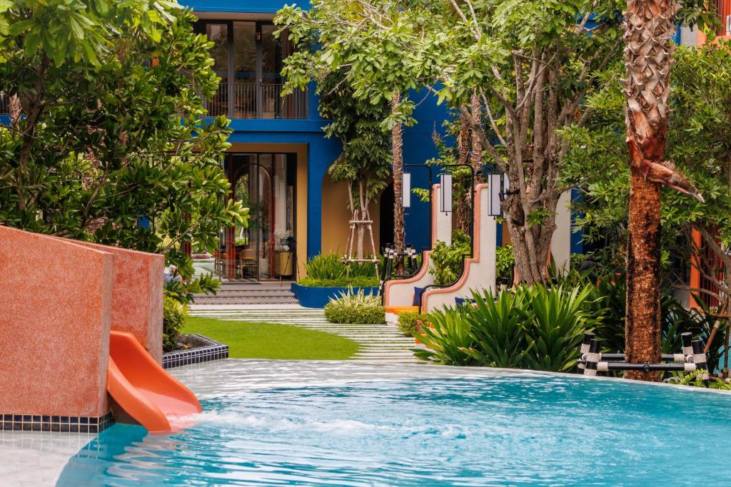 a pool at a resort with a slide at Luxury Designer Studio Sealy Bed Coffee Bar Walk to Cicada Market & Beach in Hua Hin