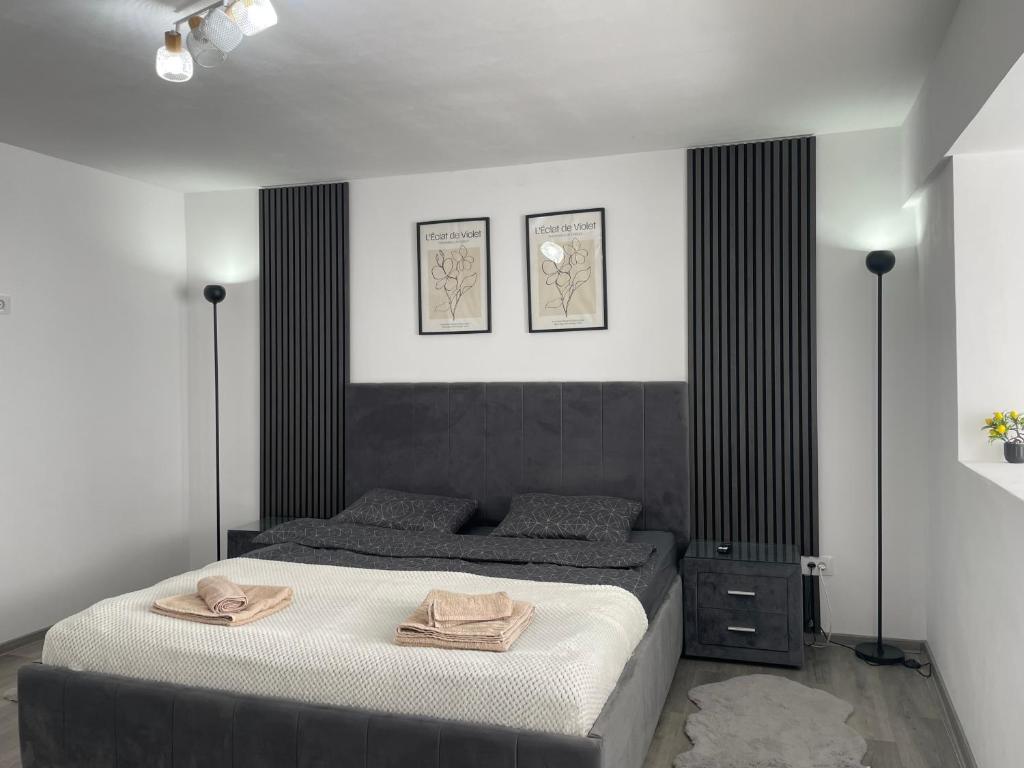 a bedroom with a bed with two towels on it at Cristal Residence in Zalău