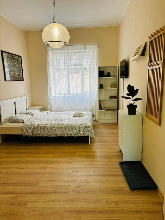 a bedroom with a bed and a large window at House1890 in Kula