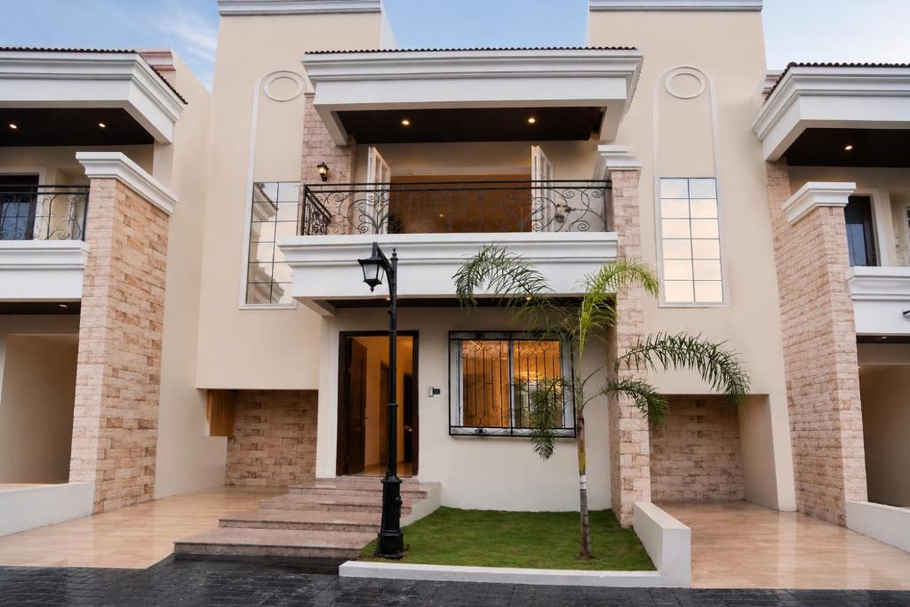 a large white house with a balcony at Vista Royal 2BHK With Private Pool in Igatpuri