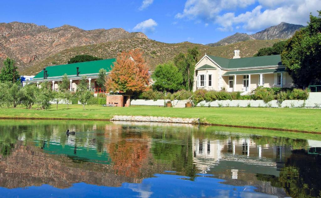 una casa vicino a un lago con montagne sullo sfondo di Montagu Vines Guesthouse a Montagu