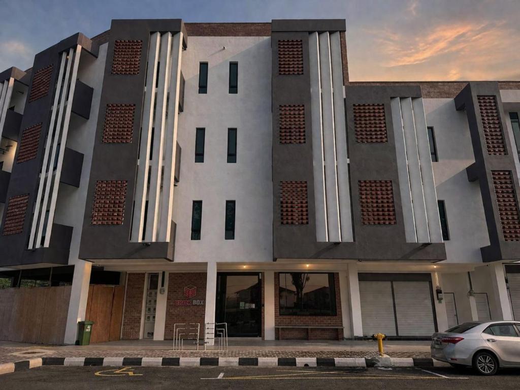 a building with a car parked in front of it at Brick Box Family Hotel Ipoh in Ipoh