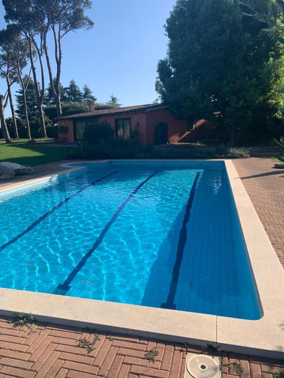 a swimming pool with blue water in front of a house at Roma country resort in Rome
