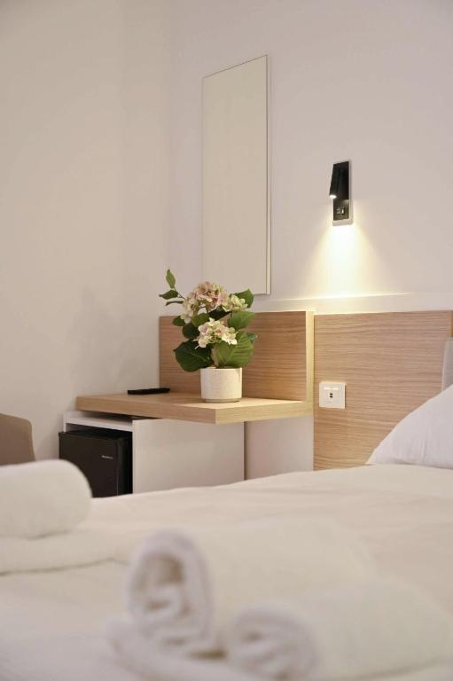 a bedroom with two beds and a potted plant on a counter at Adriatic Breeze Rooms in Mola di Bari