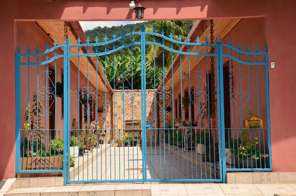 een ingang naar een gebouw met een blauwe poort bij Pousada Vila Paolino in São Pedro da Serra