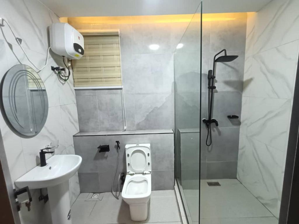 a bathroom with a shower and a toilet and a sink at House 234 in Ungwan Bado