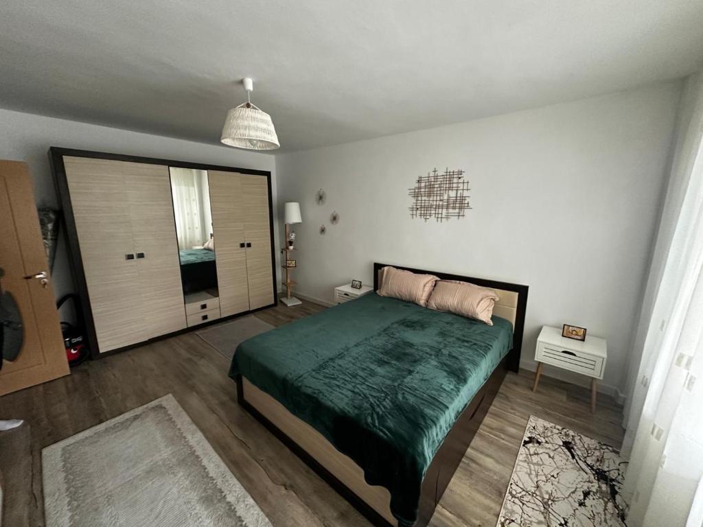 a bedroom with a bed and a large window at Dragasani Cozy Apartament in Drăgăşani