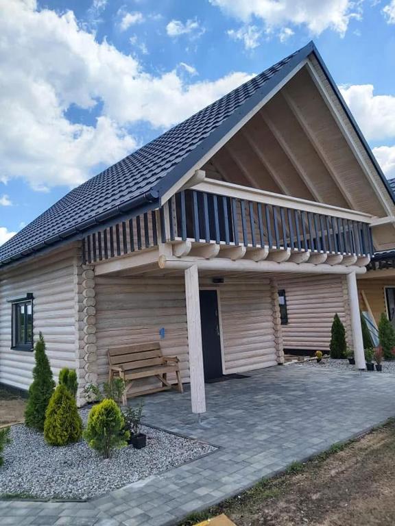 a wooden house with a bench in front of it at Domki letniskowe Malina 4 in Gawrony