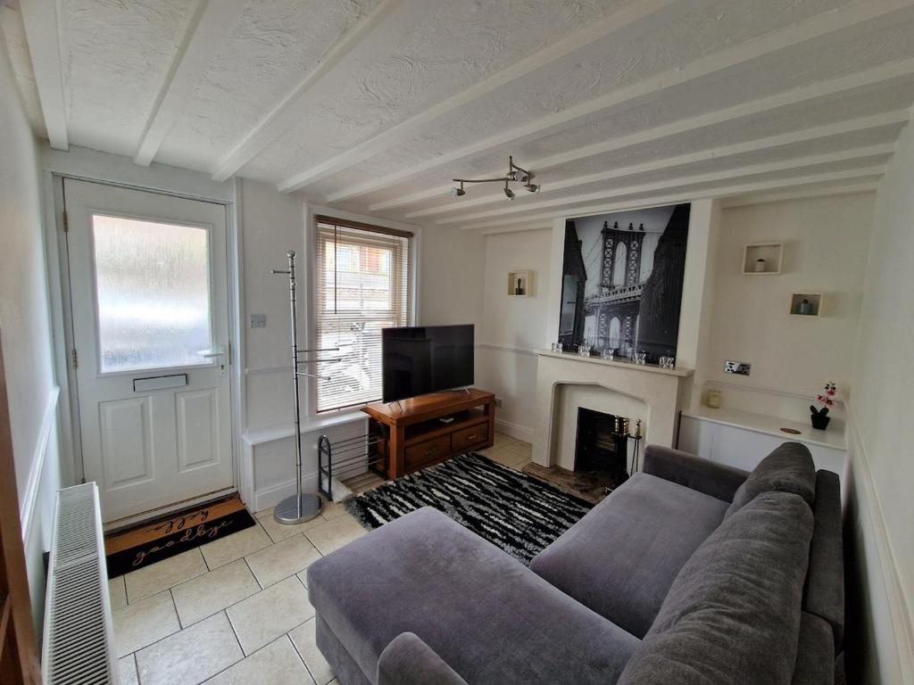 a living room with a couch and a fireplace at Carisbrooke Mill Cottage in Newport