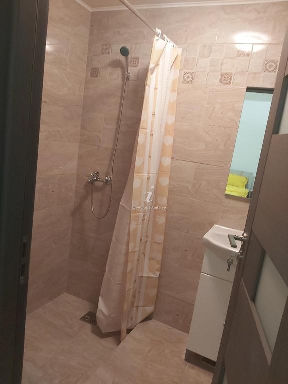 a shower with a shower curtain in a bathroom at Casa Ruja in Ocna Sibiului