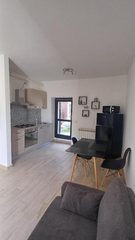 a living room with a couch and a table and a kitchen at Appartamento vicolo Torino 8 Malpensa in Ferno