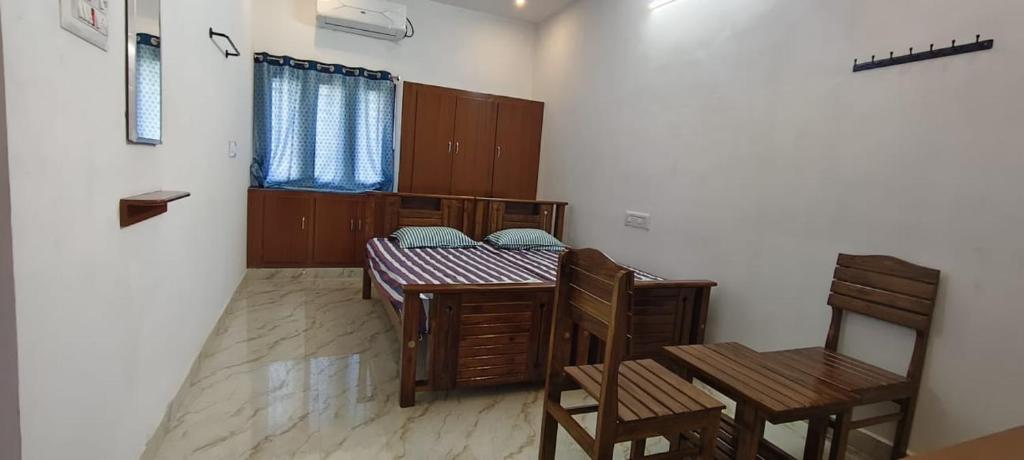 a dining room with two tables and two chairs at Santha Residency in Ambātturai