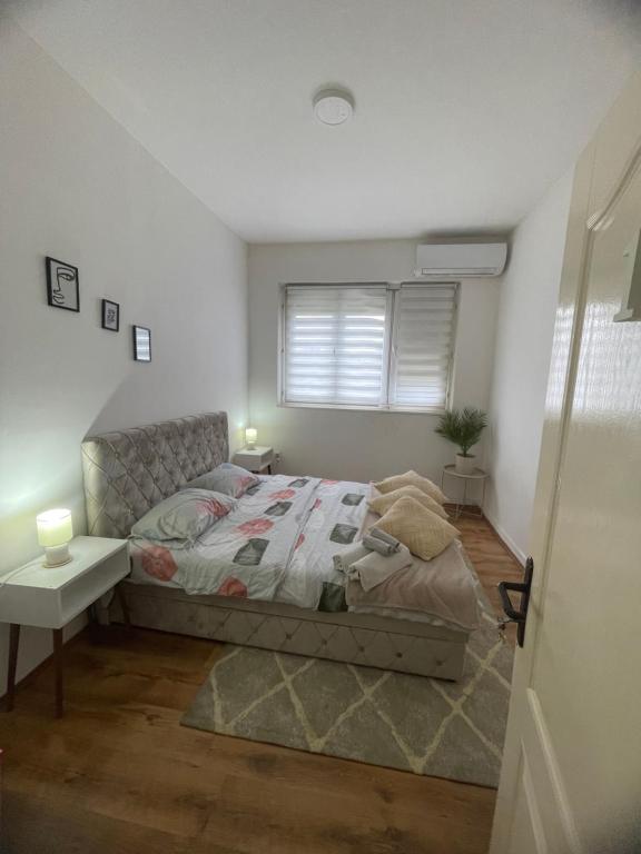 a bedroom with a bed and a table and a window at Fenix Apartman II in Zaječar