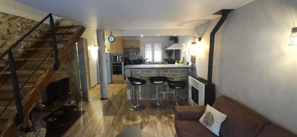 a living room with a couch and two bar stools at Charmante et Chaleureuse petite maison in Châteauneuf-du-Pape