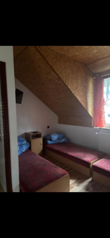 a attic bedroom with two beds and a window at Pokoje u podnóży Karkonoszy in Borowice