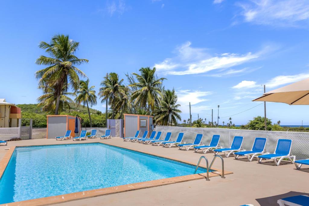 a swimming pool with lounge chairs and an umbrella at One Nice Caribbean View condo in Christiansted