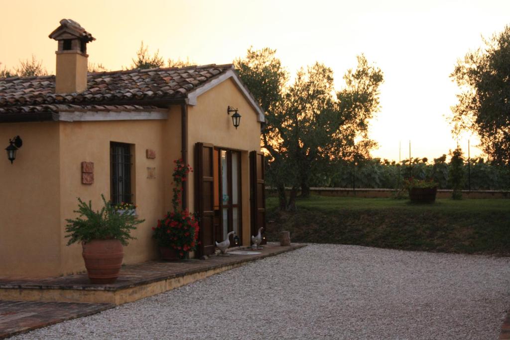 una pequeña casa con una maceta delante de ella en Agriturismo Al Crepuscolo, en Recanati